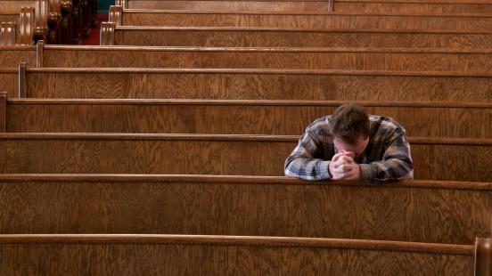 Man alone in sanctuary praying