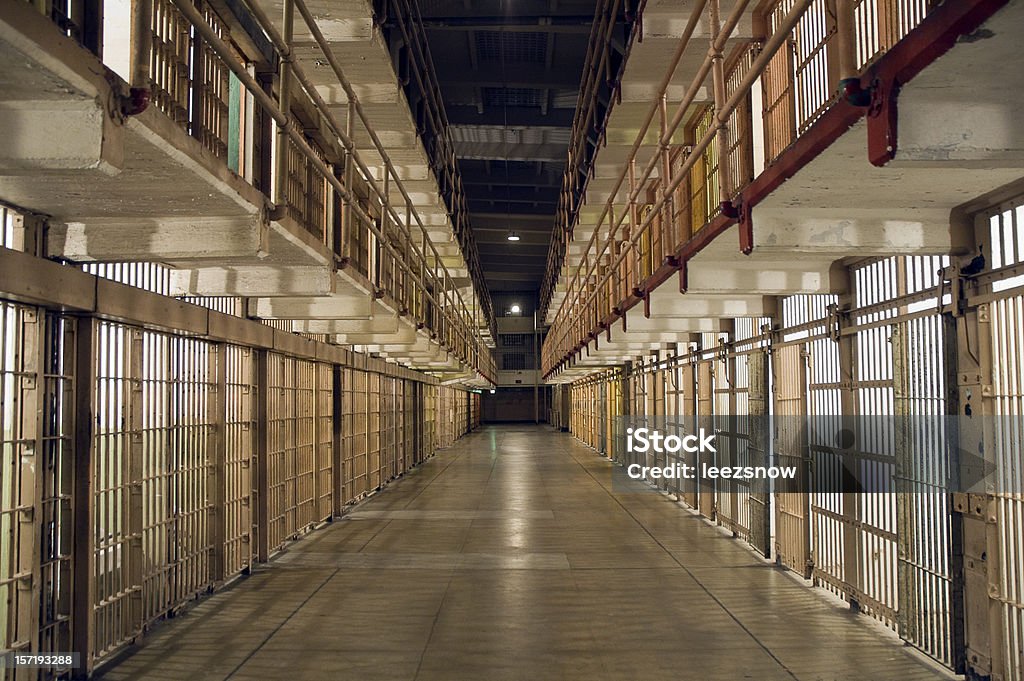 Inside Alcatraz Prison - Row of Bars and Cells Looking down a deserted aisle lined on both sides with two levels of prison cells.  Slight grain adds to the gritty atmosphere. Prison Stock Photo