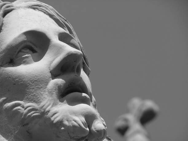 Old statue of Jesus Christ with his arms raised against grey background, from cemetery 1877, Sydney Australia, full frame vertical composition with copy space