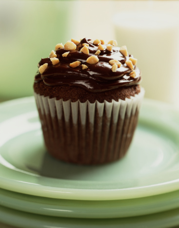 Chocolate Cupcake with peanuts on green plate.