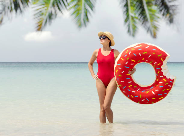 istock Beautiful woman with inflatable donut 1571945387