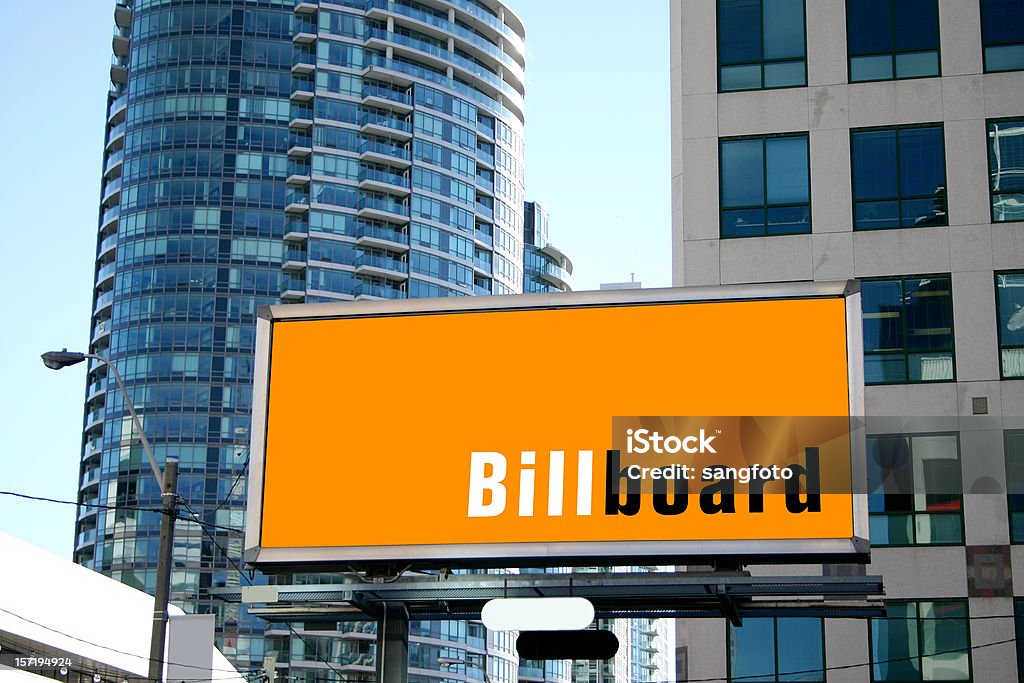 An orange billboard in a large city original ad was taken out and replace with generic billboard - you can use it to put your own ad design and as well change the orange bg color Billboard Stock Photo