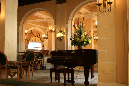 Lobby of a tropical hotel.  Grand piano with seating in foyer.