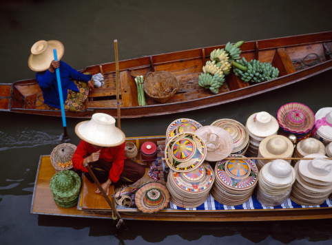 Floating market in Bangkok, Thailand. Looking down onto boats filled up with hats and vegetables ready for sale.