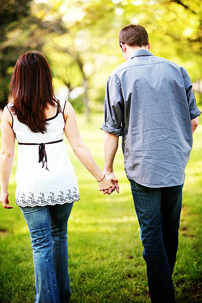istock Young Couple Holding Hands in Spring lit Park 157195470