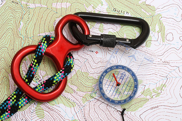 найти на горы, компас, веревки & карабин на карте серо-коричневый - orienteering planning mountain climbing compass стоковые фото и изображения
