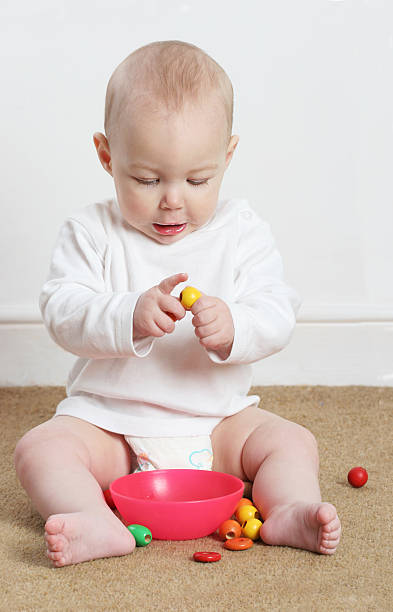 baby playing with beads baby boy playing with beads boys bowl haircut stock pictures, royalty-free photos & images