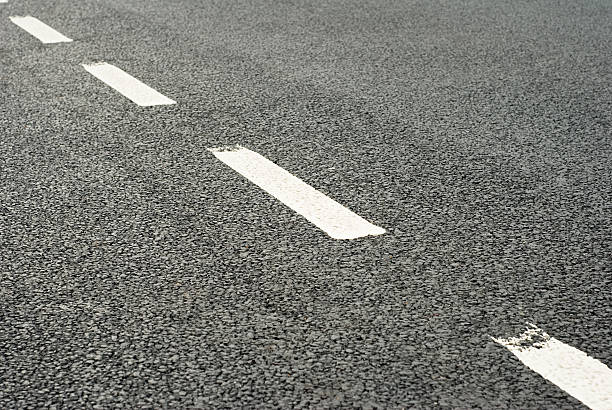 Road Markings: Dividing Line White lines dividing a freshly laid road. central reservation stock pictures, royalty-free photos & images