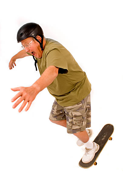 retired guy falls off his skateboard stock photo