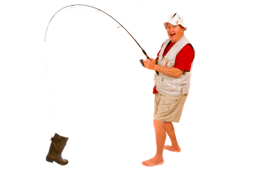 The fishing rod stands on the shore of the lake.