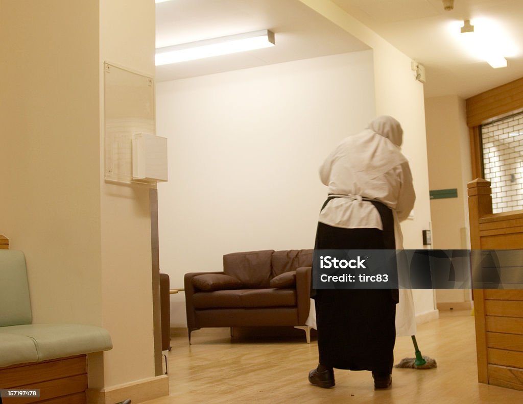 Muslim hospital cleaner Muslim cleaning lady with mop and bucket washing the floor in a hospital canteen Burka Stock Photo