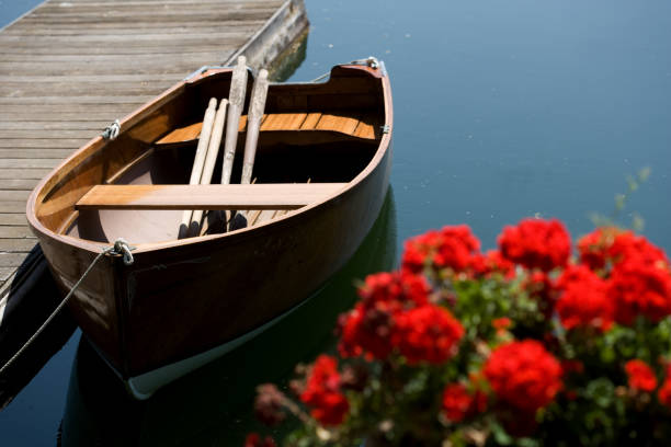 Sailing boat on an alpine lake with mountains and flowers
