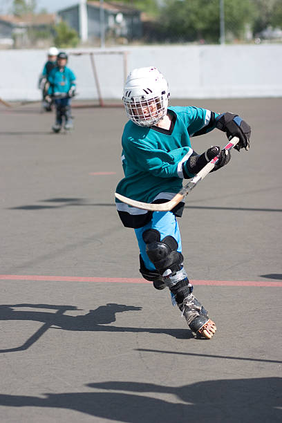 enfant qui joue le sport hockey de rue - hockey sur patins photos et images de collection