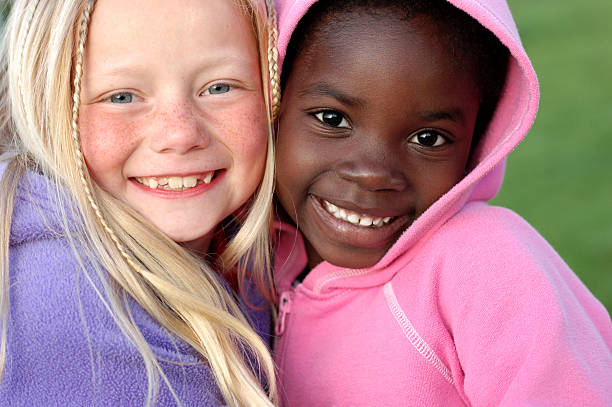 dos niñas feliz sonriendo juntos al aire libre - color de ojos fotografías e imágenes de stock