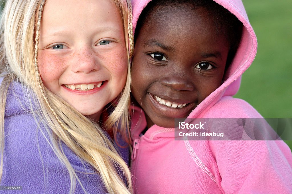 Two Happy Girls Smiling Together Outside Color photo of two adorable girls with adorable smiles!  They are sisters by adoption. Child Stock Photo