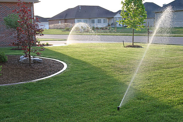 Suburban house with a sprinkler system in the front garden stock photo