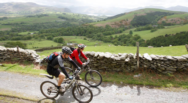 サイクリングのカップル - uk mountain color image cumbria ストックフォトと画像