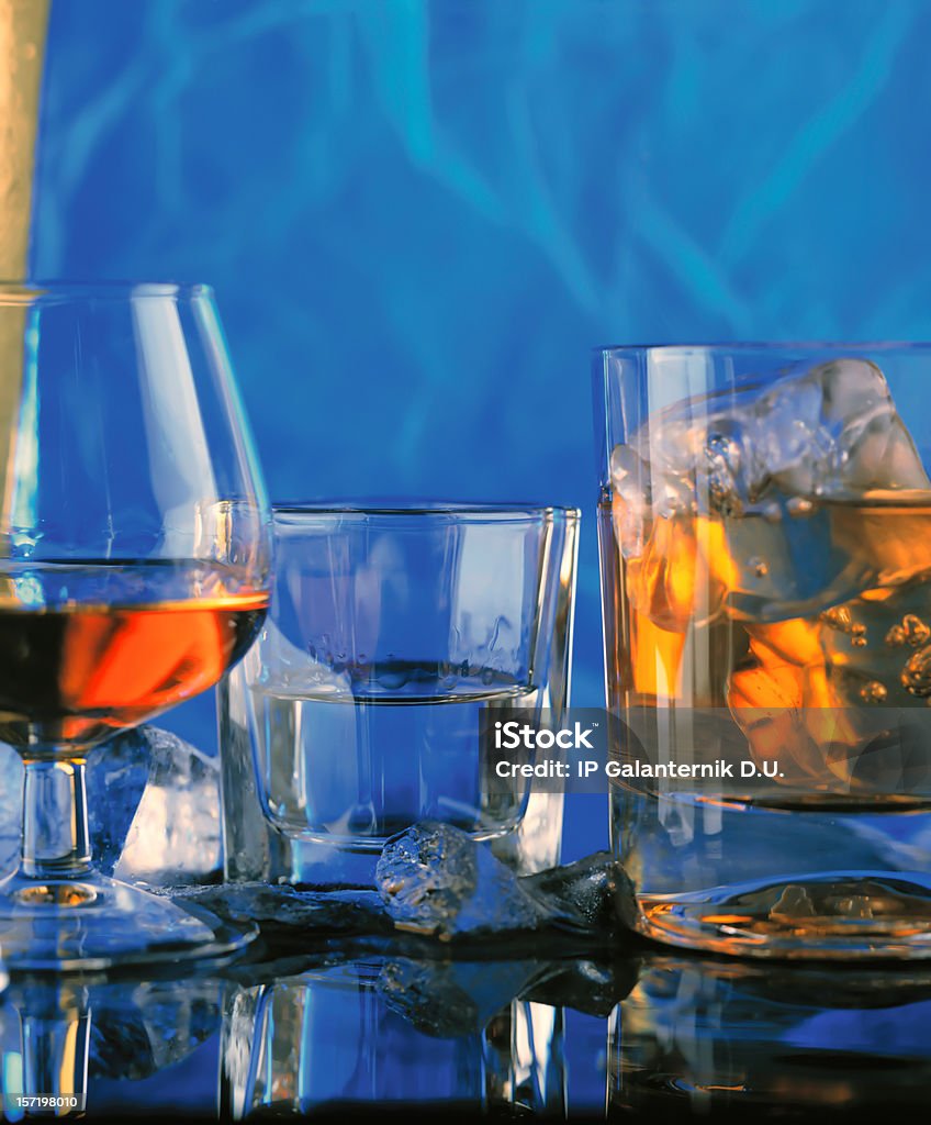 Três cápsulas óculos com álcool bebidas, reflectido na tabela. - Royalty-free Licor Foto de stock