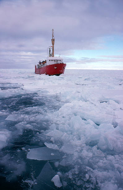 A red ice breaking ship breaking up frozen water stock photo