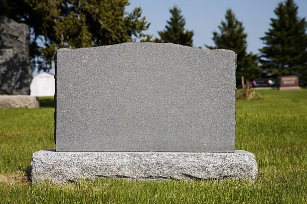 Photo of Blank gravestone in grassy graveyard