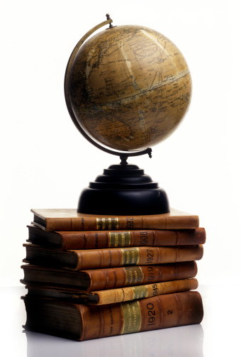 Antique Globe on a pile of old Books with leather cover isolated on white background