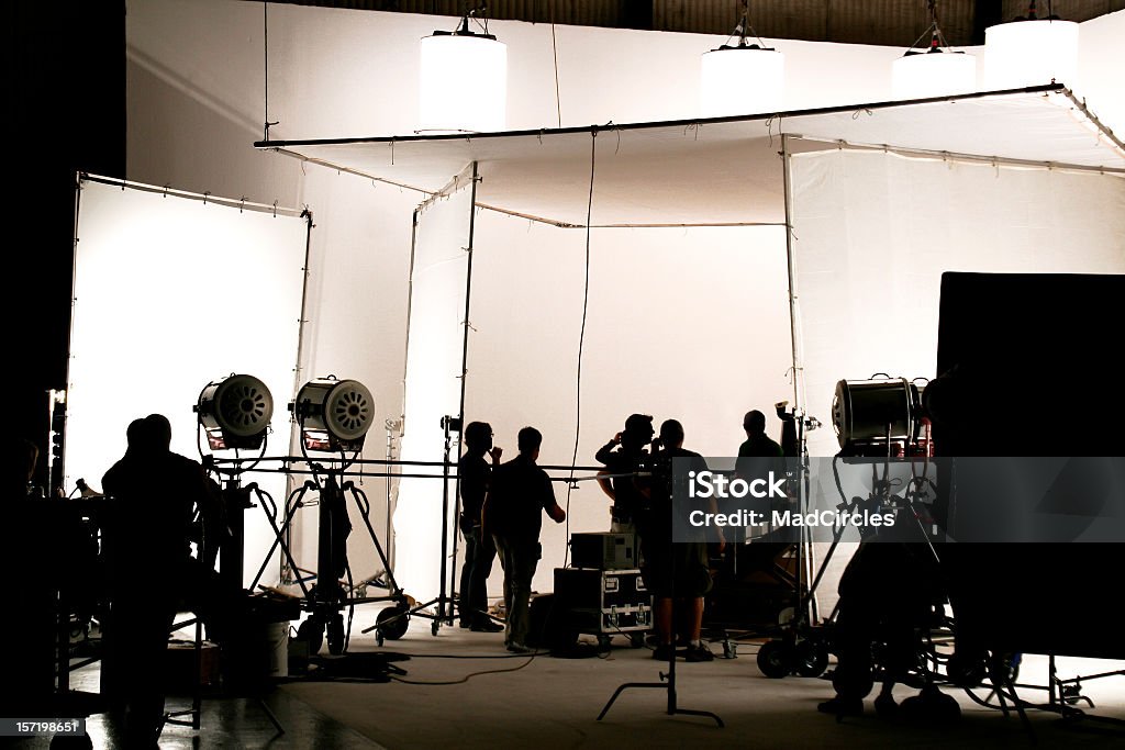 Television comercial production set. Silhouette of a production in progress on a white stage. Film Industry Stock Photo