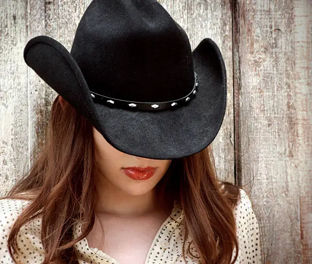 Western girl with hat covering her eyes.