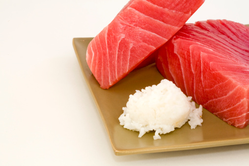 Blocks of sushi-grade fresh Ahi tuna on a plate with rice.