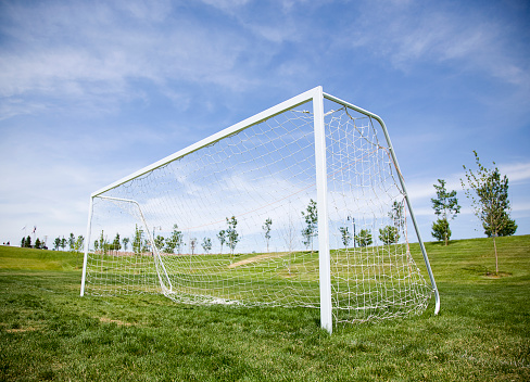 A soccer goal beneath blue sky.
