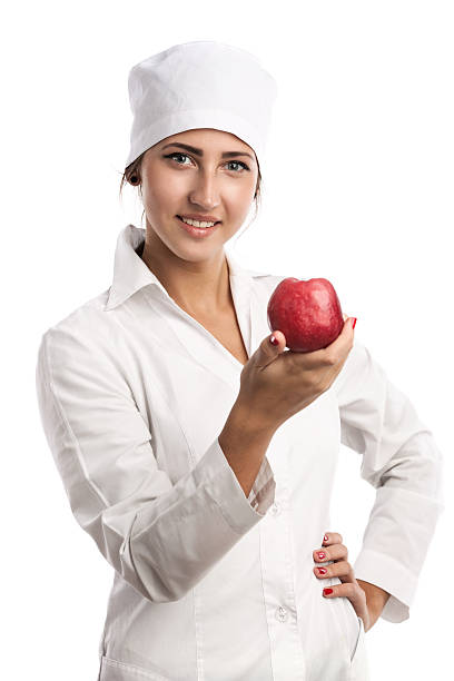 Smiling young doctor holding an apple stock photo