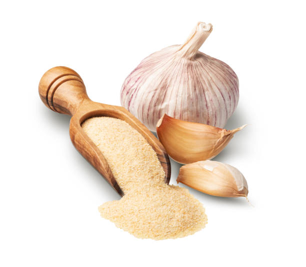 Wooden scoop with dried garlic isolated on white