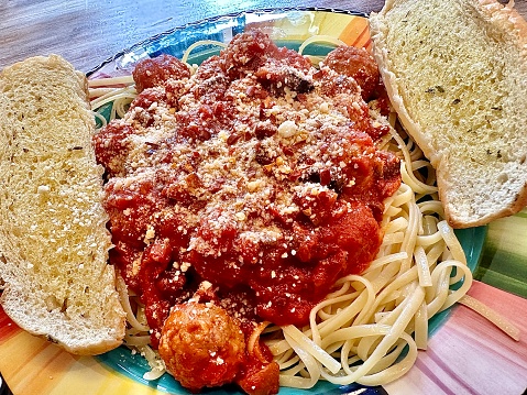 Spaghetti and meatballs with fettuccine and garlic bread.