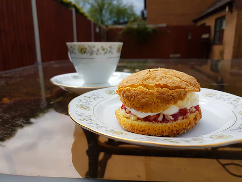 Cream tea, scone cream and jam served on a pretty China plate with a cup of tea to wash it down, indulgence at its best.