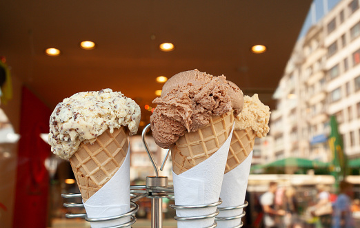 Ice cream cones on stand waiting to be eaten, luxury flavours to cool you down on a hot day.