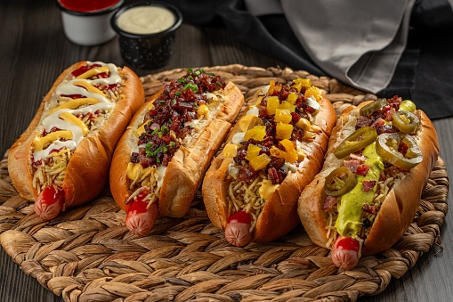 A closeup of a variety of hotdogs with delicious toppings on the table