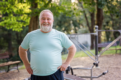 Portrait of confident body positive overweight man in outdoors gym