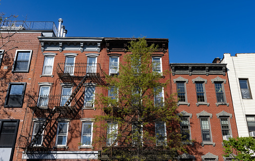 A row of beautiful and colorful old brick apartment buildings along a neighborhood street in Williamsburg Brooklyn of New York City