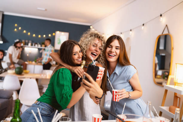 istock Girlfriends taking selfies at a house party 1572128771
