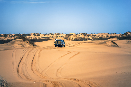 Desert safari outside Dubai, UAE. Adventure, extreme sports, tourist activities in the desert. Sport car driving on sand dunes. Orange golden sand in the desert.