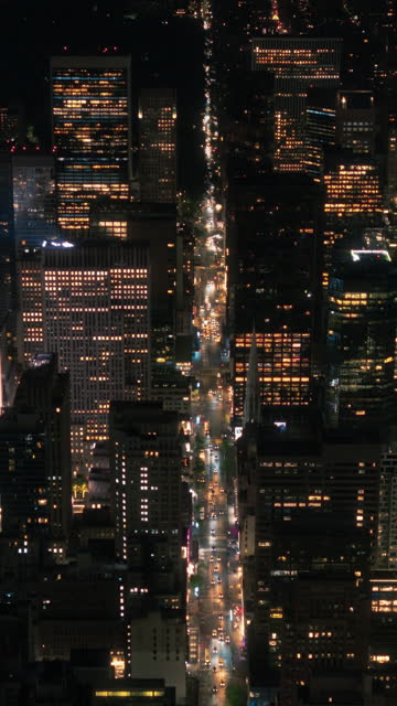 Vertical Screen: Scenic Aerial New York City View of Manhattan Architecture. Night Footage of the Business District from a Helicopter. Cityscape with Office Buildings and Busy Traffic on Streets