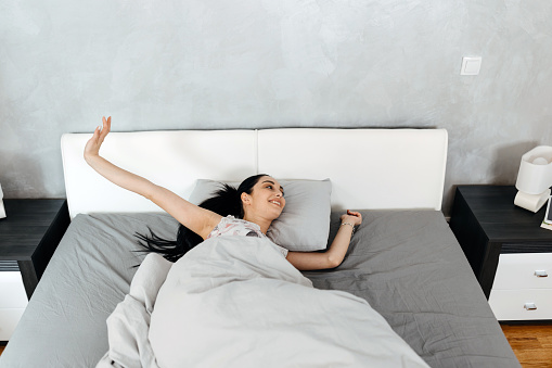 Demonstrating flexibility and mindfulness, the woman engages in arm stretches, promoting a positive and invigorated start to her day