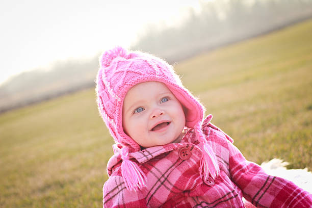 One year old girl sitting outside on a sunny winter day.