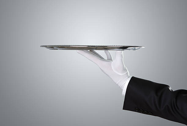 Waiter holding empty silver tray Waiter holding empty silver tray over gray background with copy space formal glove stock pictures, royalty-free photos & images