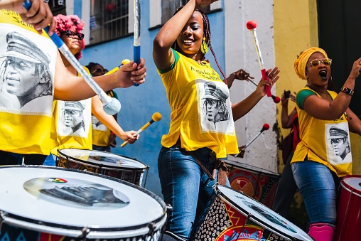 Salvador, Brazil – June 23, 2018: A group of female percussionists called Dida perform in the streets of Pelourinho, Salvador, Bahia while a men's soccer match between Brazil and Chile