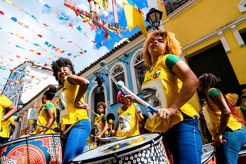 Salvador, Brazil – June 23, 2018: A group of female percussionists called Dida perform in the streets of Pelourinho, Salvador, Bahia while a men's soccer match between Brazil and Chile