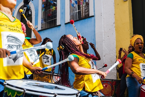 Salvador, Brazil – June 23, 2018: A group of female percussionists called Dida perform in the streets of Pelourinho, Salvador, Bahia while a men's soccer match between Brazil and Chile
