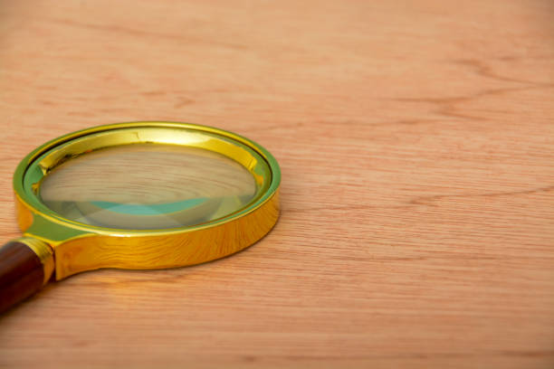 istock Magnifying glass on wooden table. Copy space. 1572248107