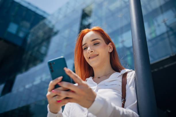 istock Woman with mobile next to buildings 1572261991
