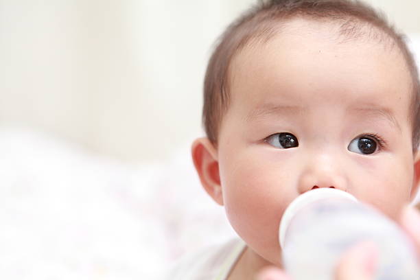 bebê com garrafa de leite - baby beautiful part of selective focus imagens e fotografias de stock