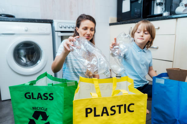 istock Selective focus on plastic bottles, concept of recycling. Mother educates son on how sort garbage into different bins on kitchen. Family sorting garbage at home. aware environmental importance 1572300959